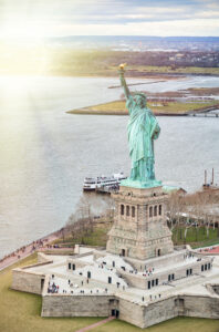 Statue of Liberty on Liberty Island and Ferry Boat with tourists, New York City.